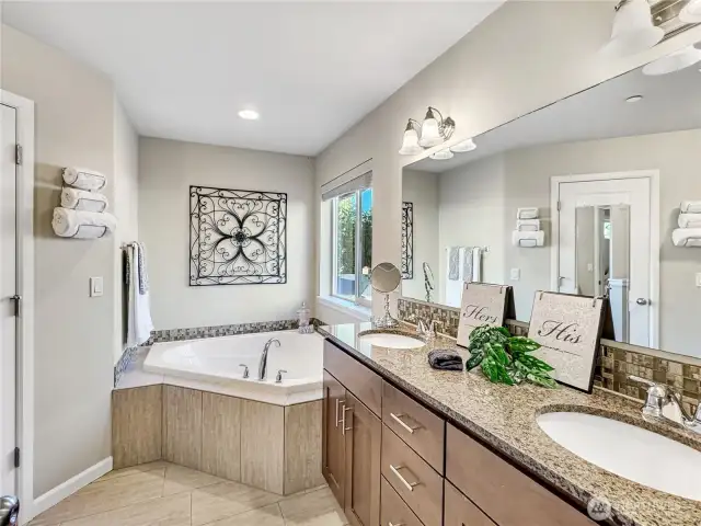 Primary bathroom has dual sink vanity, plenty of counter space, soaking tub, standing shower and walk in closet