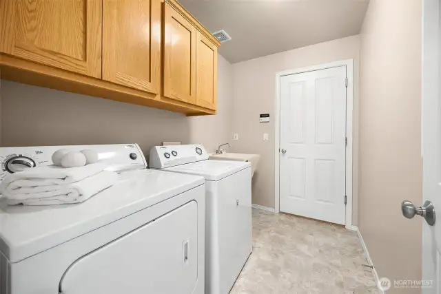 The laundry room with utility sink connects the main living level to the 3-car garage.