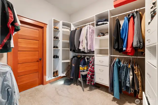 Primary walk-in closet leading to laundry room