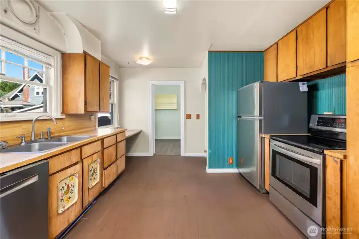 The kitchen has bountiful storage space and updated stainless appliances. Laundry room shown straight ahead.