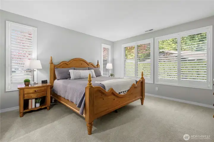 Primary bedroom with Plantation shutters overlooking the beautiful outdoor spaces.