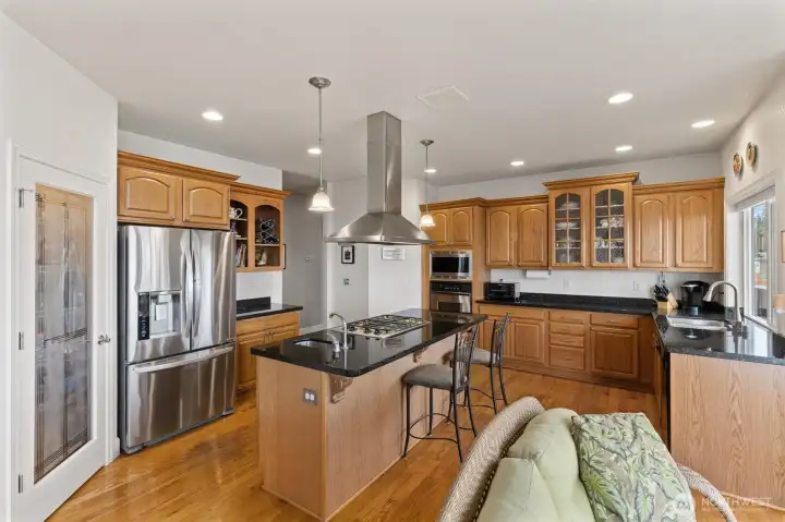 Spacious kitchen with ample storage including a walk-in pantry and slab granite counter tops.