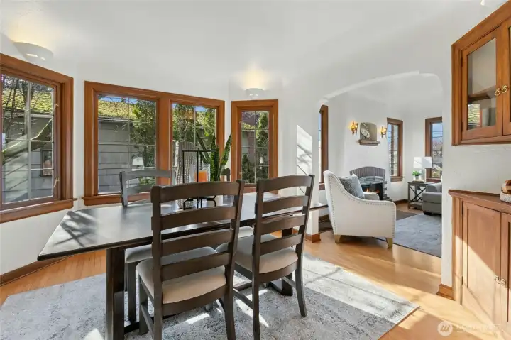 Coved ceilings, curved archways, and hardwood floors continue into dining room.