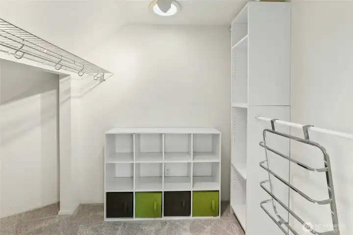 Walk-in-closet with solar tube for natural lighting attaches to primary bedroom.