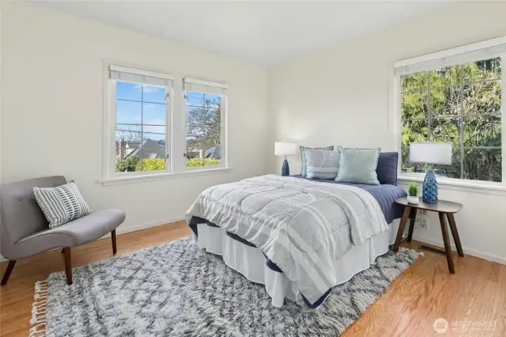 Main level bedroom has hardwood flooring and western view windows.