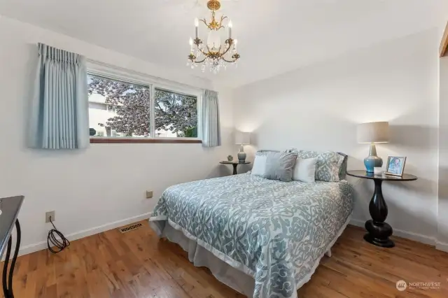 Custom lighting and hardwood flooring lend so much charm to this bedroom!