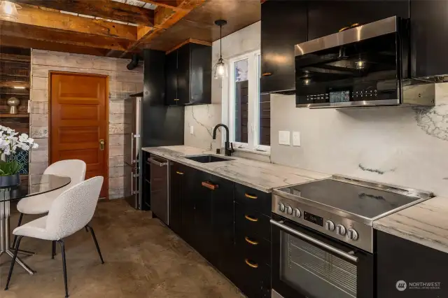 Those with a love of meal preparation will appreciate the highly functional kitchen with its stainless-steel appliances including a built-in microwave and dishwasher. Vintage charm is offered by reclaimed metal kitchen cabinets and an eye-catching corrugated steel ceiling.