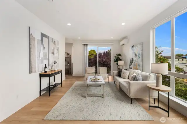 Bright and airy living room extends to a private walk-out balcony, offering fresh air and an inviting space to unwind or entertain.