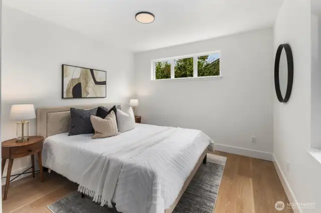 Comfortable and bright, this main floor bedroom features a large closet and warm wood floors, creating a welcoming space for guests or family