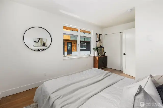 Filled with natural light from windows on two sides, this main floor bedroom offers a versatile layout and modern style for rest, work, or hobbies.