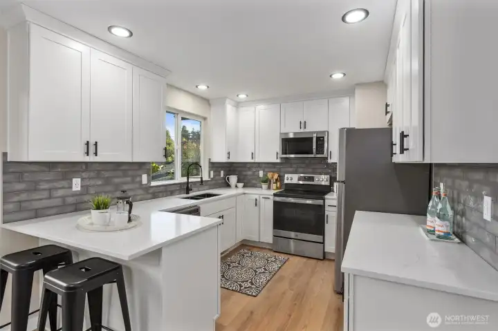 New cabinetry with Quartz counter tops, tile backsplash and stainless steel appliances