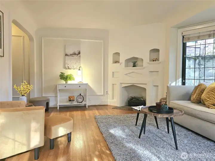 The decorative fireplace with painted millwork and recessed storage niches add to the unparalleled character of this sweet home.