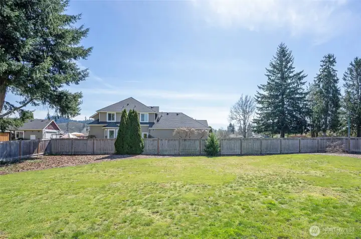 Fully fenced backyard on just under a half-acre lot, offering abundant space for play, gardening, and outdoor enjoyment.