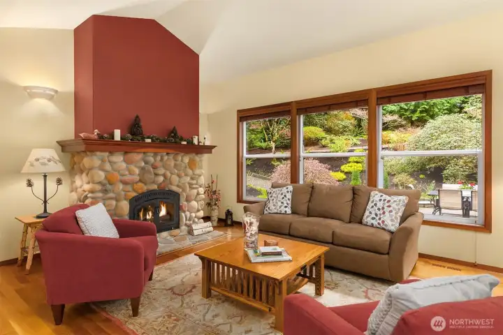 A wood-burning fireplace with river rock surround and wood mantel is the main attraction in the living room.