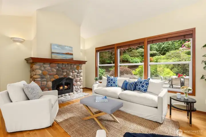 A wood-burning fireplace with river rock surround and wood mantel is the main attraction in the living room.