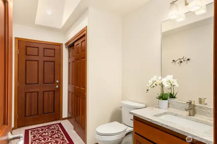 The powder room has storage and a door to the back yard - easy to come in from a day of gardening to wash your hands!
