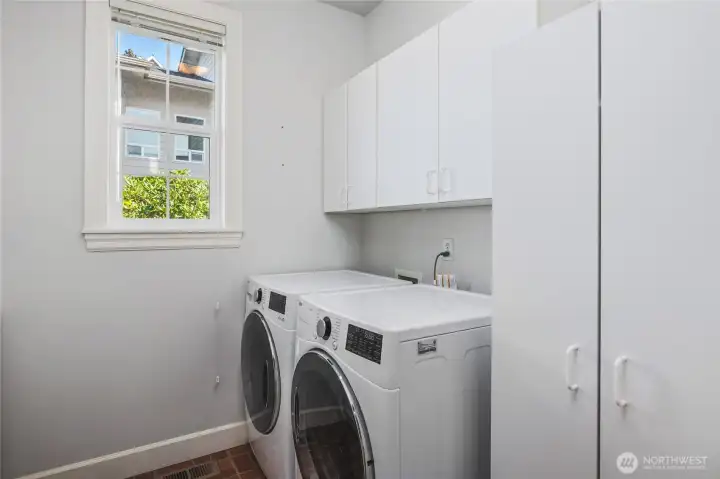 Main Level Laundry Room with Deep Sink and Cabinets for Storage