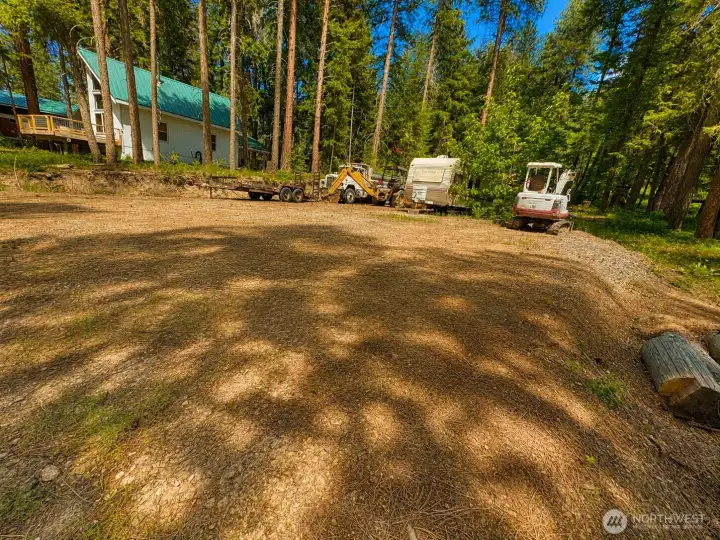 Large open-use area nestled among mature pines, offering flexibility and easy access within the community. The natural forest surroundings create a peaceful and inviting mountain retreat feel.
