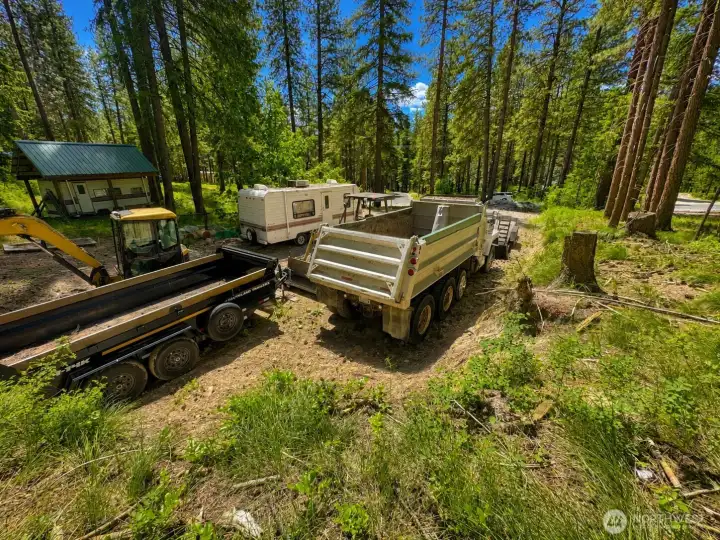 Spacious outdoor area surrounded by towering trees and peaceful forest scenery. This versatile section of the property offers excellent access and usability while maintaining a quiet mountain ambiance.
