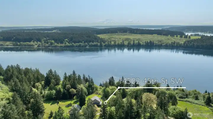 Drone looking east over passage and McNeil Island with Cascades in the background.