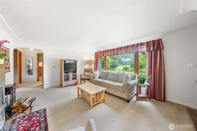 Living room with a large window and yard view.