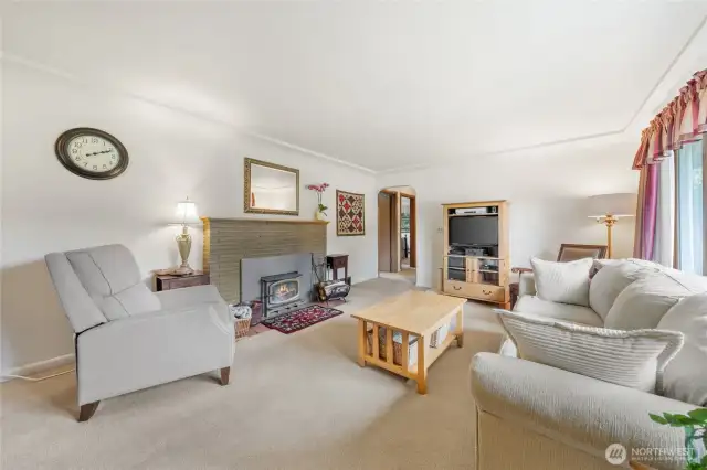 Charming living room centered around a wood-burning fireplace.  Change of the look of the home and pull back the carpet to show off hardwood floors.