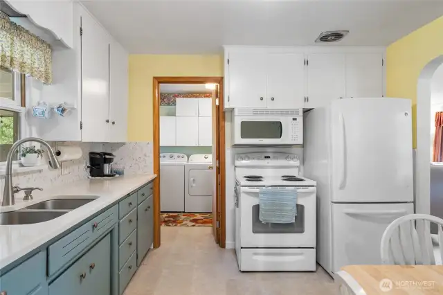 White cabinetry and easy, direct access to the adjacent laundry room.