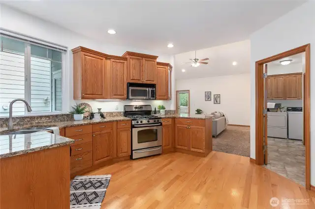 Cook's kitchen w/ oak floors, stone counters and stainless appliances