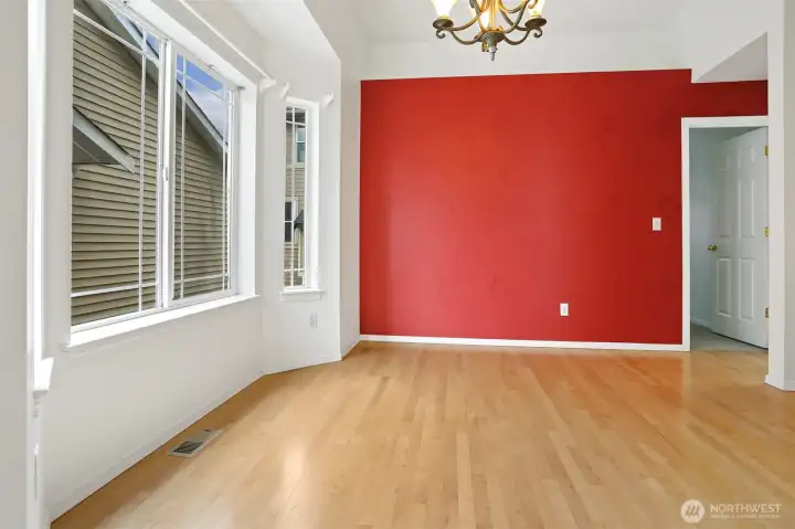 The door to the right of the red wall leads to the primary bedroom.