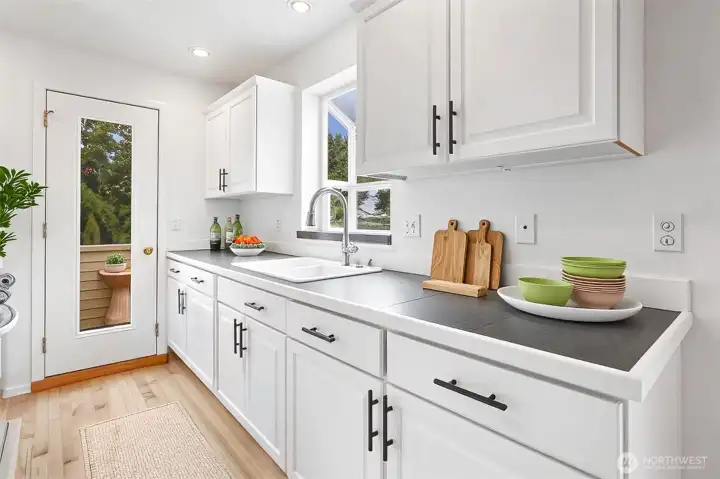 Refinished hardwood floors and freshly painted kitchen cabinets.