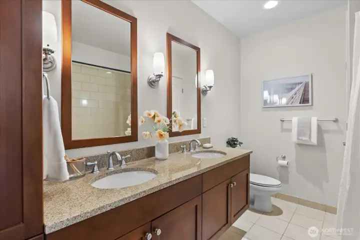 Just adjacent to guest bedroom is a full bath with dual sink vanitie, built-in storage cabinetry and separate linen closet.