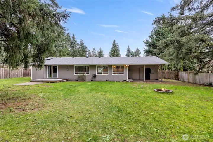 Fully-fenced backyard with covered patio off the kitchen and deck off the primary bedroom.
