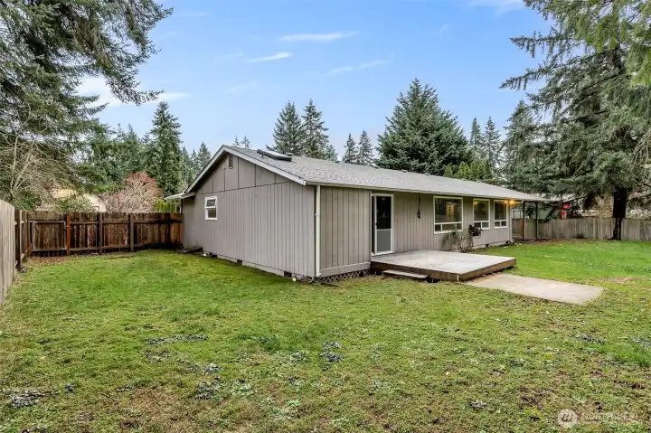 Fully-fenced backyard with covered patio off the kitchen and deck off the primary bedroom.