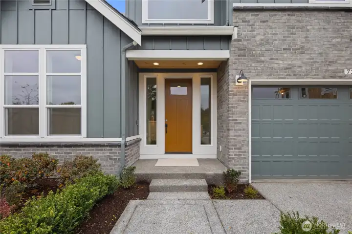 Covered Entry:  A warm wood-tone door anchors the sheltered entryway, framed by sidelights that draw natural light into the foyer while highlighting the clean exterior palette. The generous overhang and simple landscaping provide a comfortable transition between the outdoors and the home’s interior. Located in Bothell’s Canyon Park corridor, the entry sets the tone for a lifestyle centered around convenience, access to trails and dining, and an easy commute to I-405. The understated detailing adds a refined, modern character that welcomes guests with simplicity and style.    These photos are from Lot 5 at Gooden Hollow, the home listed here. However, other homes in the community will have changes, so all photos, renderings, site maps, and floorplans are for visualization purposes only. Plans, colors, building orientation, finishes, home outlook, and other details can and WILL vary.