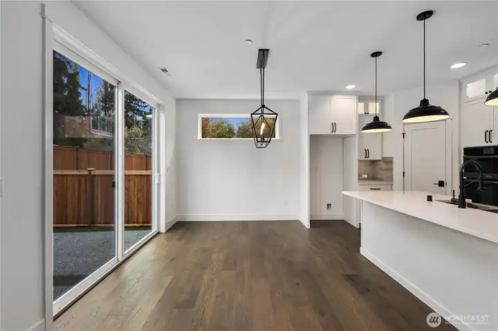 Dining Area:  This airy dining space is framed by wide-plank flooring and anchored by a sculptural modern chandelier that adds definition without overwhelming the openness. The room’s proximity to the kitchen and backyard supports easy transitions between weeknight meals, gathering, and indoor–outdoor entertaining. Situated in Bothell’s Canyon Park micro-area, the home offers quick access to nearby parks, trails, and everyday amenities while remaining close to major commuter connections. The clean lines and natural light make this dining area versatile enough for both casual living and more elevated occasions.    These photos are from Lot 5 at Gooden Hollow, the home listed here. However, other homes in the community will have changes, so all photos, renderings, site maps, and floorplans are for visualization purposes only. Plans, colors, building orientation, finishes, home outlook, and other details can and WILL vary.