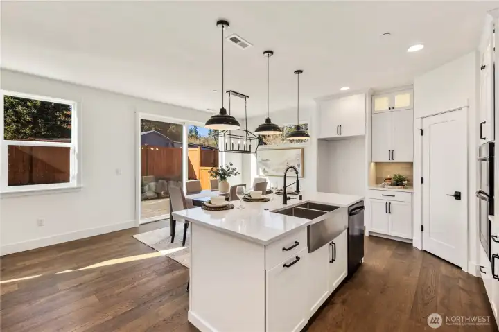 Dining Area:  This airy dining space is framed by wide-plank flooring and anchored by a sculptural modern chandelier that adds definition without overwhelming the openness. The room’s proximity to the kitchen and backyard supports easy transitions between weeknight meals, gathering, and indoor–outdoor entertaining. Situated in Bothell’s Canyon Park micro-area, the home offers quick access to nearby parks, trails, and everyday amenities while remaining close to major commuter connections. The clean lines and natural light make this dining area versatile enough for both casual living and more elevated occasions.    These photos are from Lot 5 at Gooden Hollow, the home listed here. However, other homes in the community will have changes, so all photos, renderings, site maps, and floorplans are for visualization purposes only. Plans, colors, building orientation, finishes, home outlook, and other details can and WILL vary.