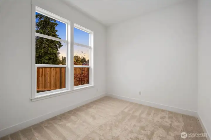 Den / Home Office:  Tall windows frame greenery and bring natural light into this spacious den, creating an inviting setting for focused work, creative projects, or quiet reading. Located on the main level and separate from the guest bedroom, it provides the additional dedicated space today’s lifestyles often require. Its position in Bothell’s Canyon Park neighborhood keeps you close to trails, local cafés, and community conveniences, enriching both productivity and day-to-day living. With its clean lines and modern proportions, this den offers a flexible, elevated workspace.    These photos are from Lot 5 at Gooden Hollow, the home listed here. However, other homes in the community will have changes, so all photos, renderings, site maps, and floorplans are for visualization purposes only. Plans, colors, building orientation, finishes, home outlook, and other details can and WILL vary.