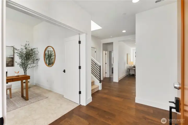 Entry & Hall (Featuring Office/Den):  The welcoming entry opens to a light-filled hallway accented by wood flooring and clean modern trim, creating a polished first impression. Just off the foyer, the main-level office/den offers immediate flexibility for remote work, meetings, or quiet focus while remaining connected to the heart of the home. Located within Bothell’s Canyon Park corridor, the home benefits from convenient access to parks, Northshore schools, and major commuter routes. The thoughtful sightlines and balanced proportions make this entry sequence feel open, organized, and seamlessly integrated into daily Northwest living.    These photos are from Lot 5 at Gooden Hollow, the home listed here. However, other homes in the community will have changes, so all photos, renderings, site maps, and floorplans are for visualization purposes only. Plans, colors, building orientation, finishes, home outlook, and other details can and WILL vary.