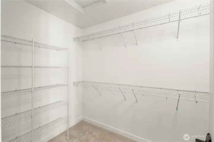 Primary Walk-In Closet:  The walk-in closet offers extensive built-in shelving and hanging space, creating an organized extension of the primary suite. Its layout maximizes capacity while keeping everything within easy reach. Thanks to the home’s location in Bothell’s Canyon Park area, the suite benefits from a peaceful residential environment close to shopping, cafés, and community conveniences. This well-sized closet adds everyday ease and helps maintain the calm, uncluttered feel throughout the suite.    These photos are from Lot 5 at Gooden Hollow, the home listed here. However, other homes in the community will have changes, so all photos, renderings, site maps, and floorplans are for visualization purposes only. Plans, colors, building orientation, finishes, home outlook, and other details can and WILL vary.