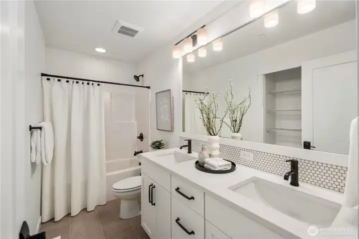 Upper-Level Full Bathroom:  This well-appointed full bath blends modern styling with everyday functionality, featuring a long quartz-topped dual-sink vanity, matte black hardware, and a full-height mirror that brightens the space. The wide layout supports easy morning routines, while the tiled flooring and thoughtful storage keep the room feeling tidy and efficient. Located in the heart of Bothell’s Canyon Park area, the home places you minutes from local trails, cafés, and schools while maintaining excellent access to I-405. Subtle details—like the penny-tile backsplash and streamlined lighting—add a polished, elevated feel that complements the rest of the home.    These photos are from Lot 5 at Gooden Hollow, the home listed here. However, other homes in the community will have changes, so all photos, renderings, site maps, and floorplans are for visualization purposes only. Plans, colors, building orientation, finishes, home outlook, and other details can and WILL vary.