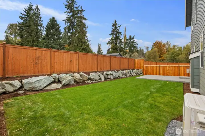Backyard:  The fully fenced backyard offers a wide lawn, handsome rockery, and a sense of privacy enhanced by mature evergreens beyond the fence line. With plenty of level space, it’s ideal for outdoor relaxation, gatherings, or quiet moments at home. Located in the heart of Bothell near Canyon Park and local trail systems, this yard captures the best of Pacific Northwest outdoor living. The large patio extends the home’s usable space, perfect for dining, grilling, or year-round enjoyment.    These photos are from Lot 5 at Gooden Hollow, the home listed here. However, other homes in the community will have changes, so all photos, renderings, site maps, and floorplans are for visualization purposes only. Plans, colors, building orientation, finishes, home outlook, and other details can and WILL vary.