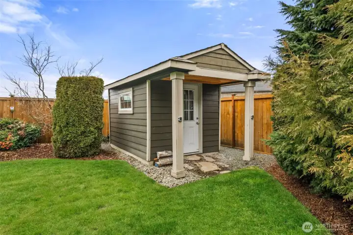 Custom storage shed complementing the landscaped grounds.