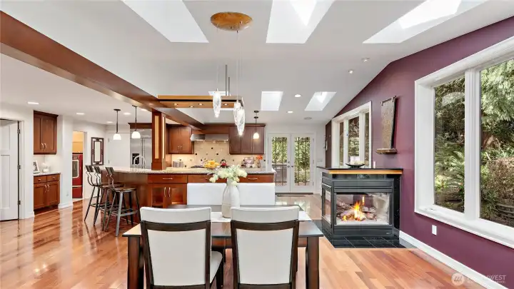 The three-sided glass fireplace brings both warmth and beauty to the space, while the custom burled maple and glass pendant chandelier adds such a striking, artful presence overhead. Together, they make this room especially memorable.
