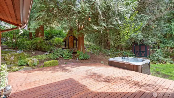 First, your eye is drawn to the 5-person spa, ready for a relaxing soak at the end of the day. Beyond it, the charming shed with its front door and peaked roof adds a delightful touch, while a second shed behind the spa offers convenient everyday storage.