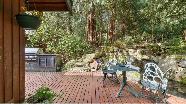 At this end, the deck opens up once again, revealing more stone steps, the outdoor kitchen, and an extraordinary multi-tiered waterfall. The whole scene is so thoughtfully composed, with each element drawing you naturally to the next.