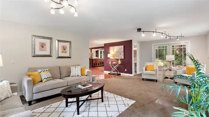 The expansive living room offers a gracious sense of separation from the kitchen, creating another inviting space to gather or unwind. Additional French doors open to the back deck, keeping the connection to the outdoors close at hand.