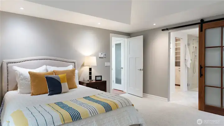 The ensuite was just remodeled, and the sliding walnut ripple glass door gives you a beautiful sense of what’s to come. Let’s step inside.