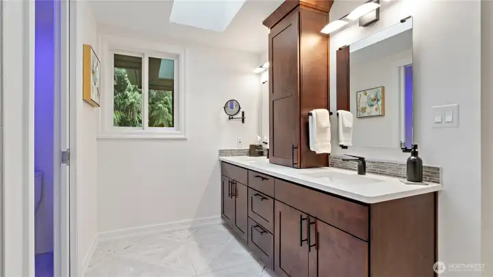 The dual-sink vanity offers generous storage, and the skylight overhead brings in such a soft, natural glow. It’s a detail that gives this space both everyday ease and a beautifully streamlined look.