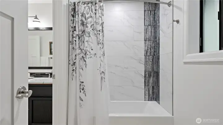 This updated bath was done in such a fresh, polished way. The crisp tile, darker accent surround, and rich vanity tones give the space a clean, current look with just the right amount of contrast. This updated bath was done in such a fresh, polished way. The crisp tile, darker accent surround, and rich vanity tones give the space a clean, current look with just the right amount of contrast.