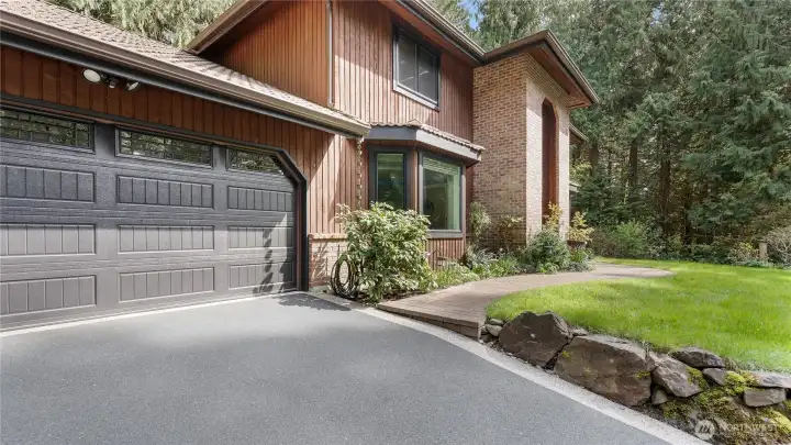 Another thoughtful upgrade, this 100% recycled rubber EcoPaved driveway offers a handsome look along with added traction underfoot. And the recently replaced insulated garage doors are another welcome improvement.